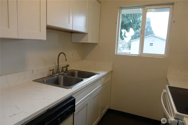 a kitchen with a sink cabinets and a window