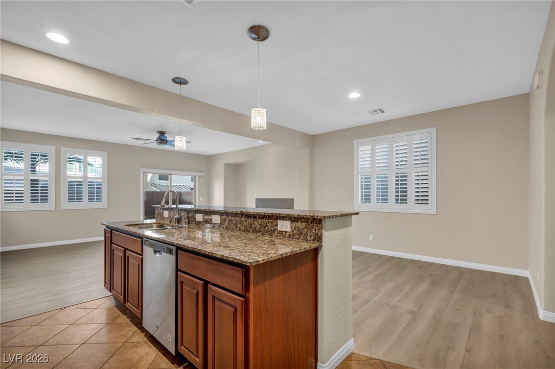 356 Aqua Springs Road Las Vegas, NV 89148 - Photo 16 of 39 Kitchen with recessed lighting, dark stone counters, pendant lighting, an island with sink, and dishwasher