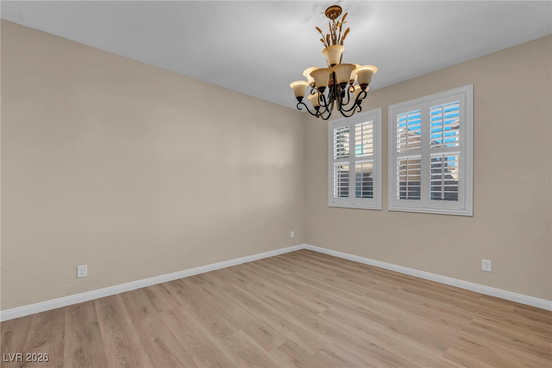 356 Aqua Springs Road Las Vegas, NV 89148 - Photo 21 of 39 Empty room with light wood-type flooring and a chandelier