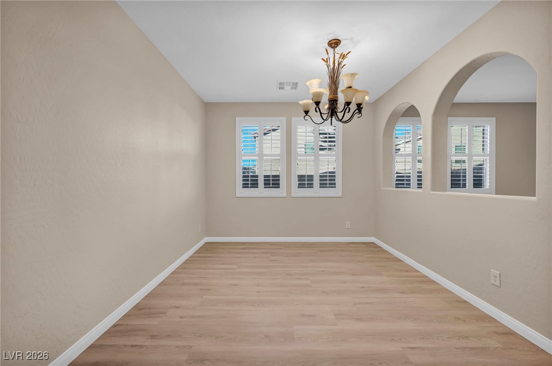 356 Aqua Springs Road Las Vegas, NV 89148 - Photo 22 of 39 Unfurnished room featuring light wood finished floors and a chandelier