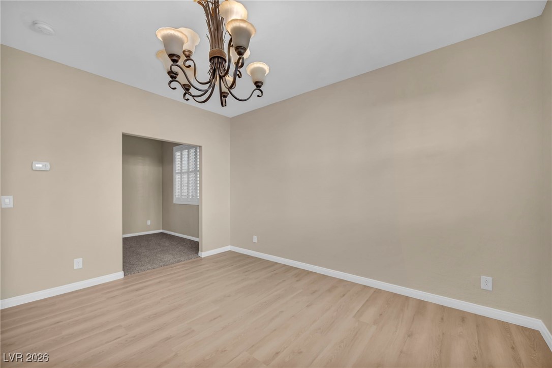 356 Aqua Springs Road Las Vegas, NV 89148 - Photo 23 of 39 Unfurnished room featuring a chandelier and light wood-style floors