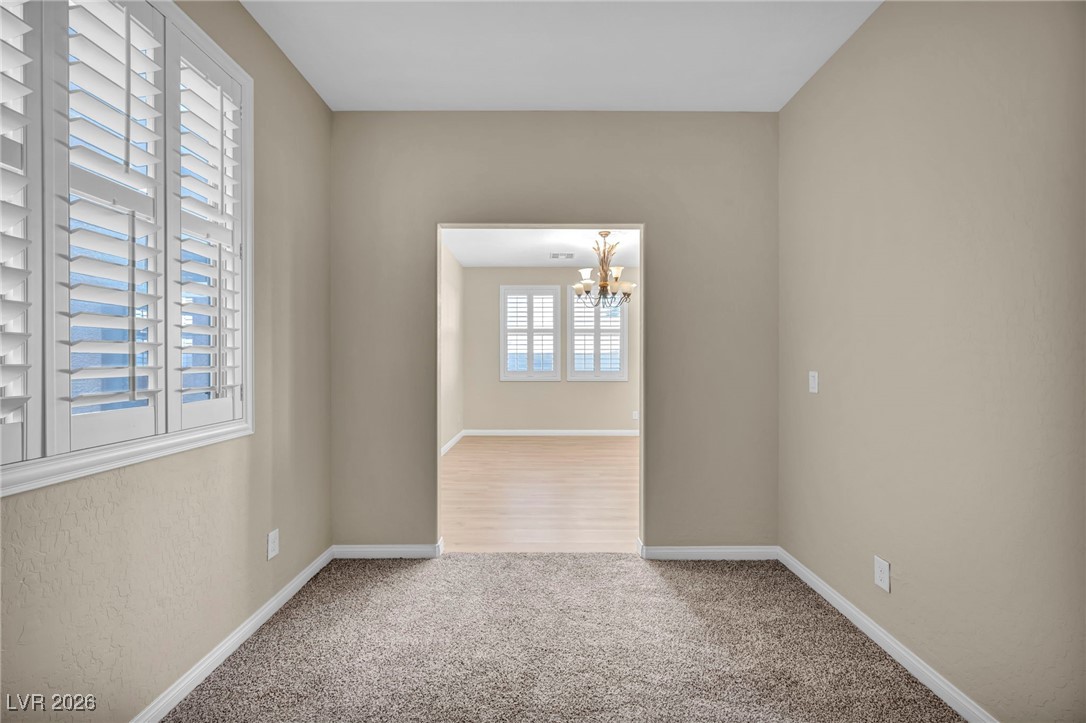 356 Aqua Springs Road Las Vegas, NV 89148 - Photo 24 of 39 Spare room featuring light carpet and a chandelier