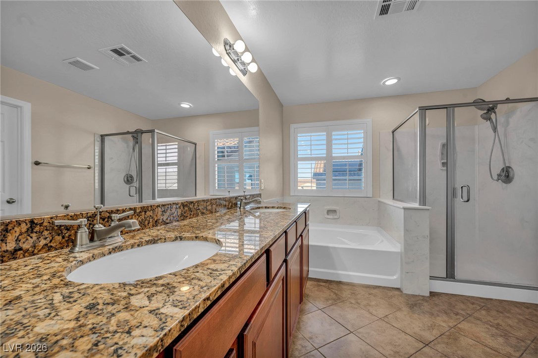 356 Aqua Springs Road Las Vegas, NV 89148 - Photo 31 of 39 Full bathroom featuring a shower stall, double vanity, light tile patterned floors, and a bath