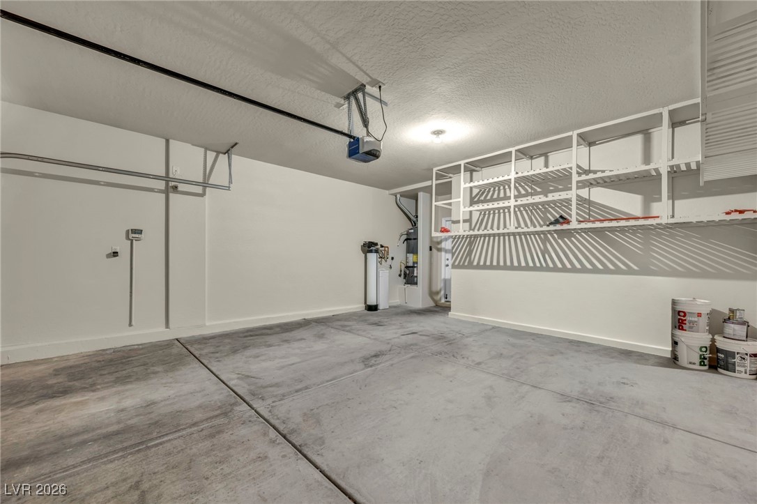 356 Aqua Springs Road Las Vegas, NV 89148 - Photo 34 of 39 Garage featuring water heater and a garage door opener