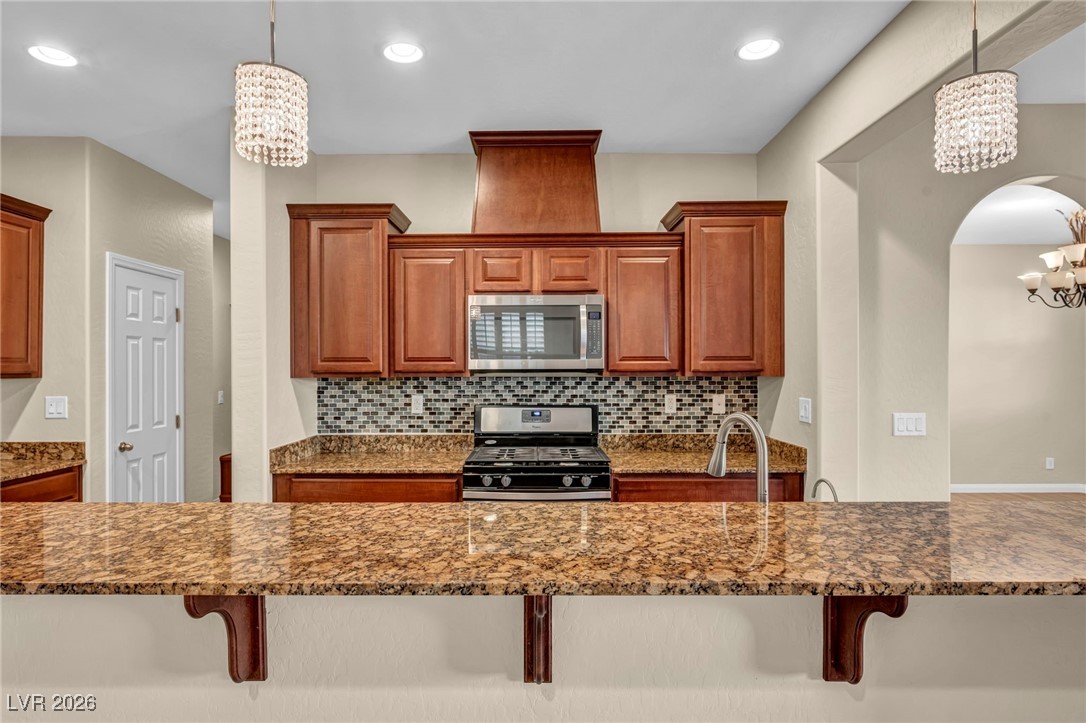 356 Aqua Springs Road Las Vegas, NV 89148 - Photo 9 of 39 Kitchen with a chandelier, pendant lighting, stainless steel appliances, and recessed lighting
