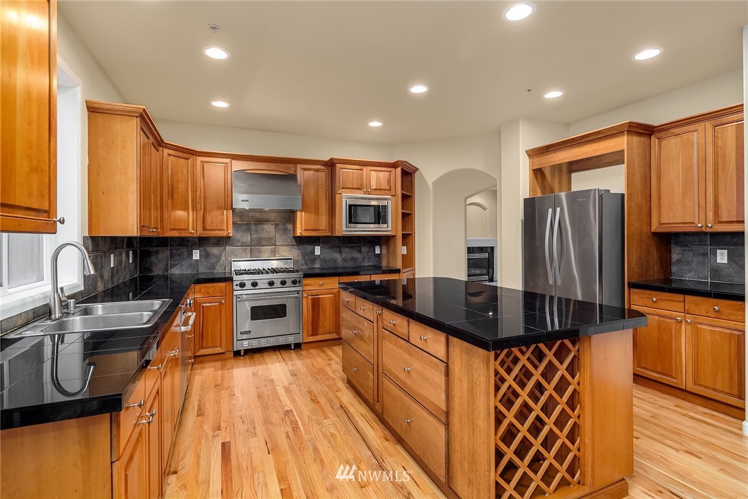 4209 Northeast 27th Place Renton, WA 98059 - Photo 15 of 35 a kitchen with stainless steel appliances granite countertop a sink a stove a refrigerator cabinets and a counter top space