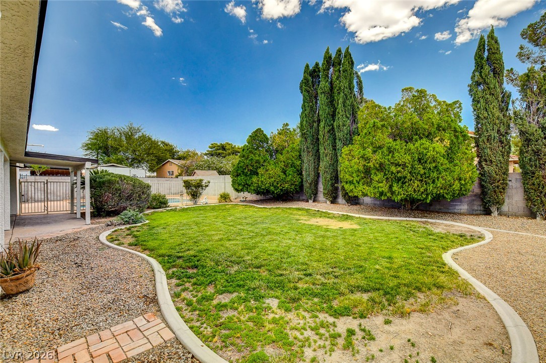 1810 Pinto Road Henderson, NV 89002 - Photo 42 of 53 A well-maintained lawn and surrounding gravel path create a serene outdoor retreat.