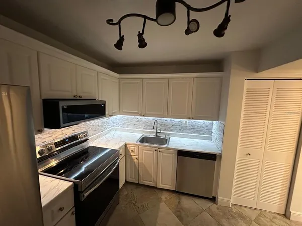 a kitchen with stainless steel appliances granite countertop a stove sink and cabinets
