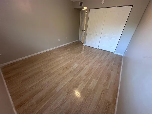 an empty room with wooden floor and entrance