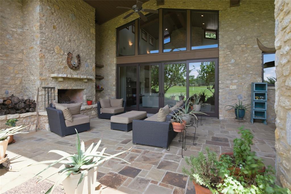 1138 Bancroft Road Keller, TX 76248 - Photo 34 of 39 Expansive outdoor patio featuring an impressive stone fireplace, a stone accent wall, and stone flooring