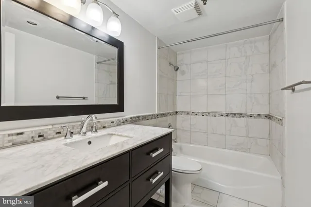 a bathroom with a sink a toilet a mirror and shower