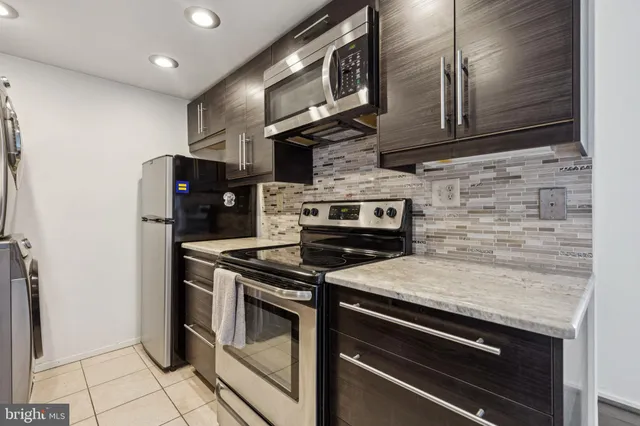 a kitchen with stainless steel appliances granite countertop a stove microwave and refrigerator