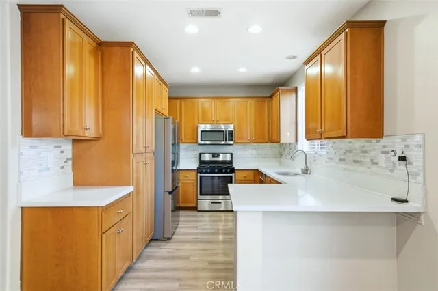 a kitchen with stainless steel appliances granite countertop a refrigerator stove and sink