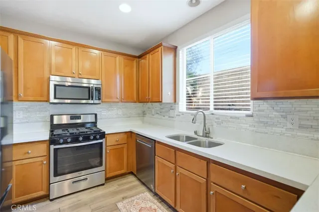 a kitchen with a sink cabinets wooden floor and a window