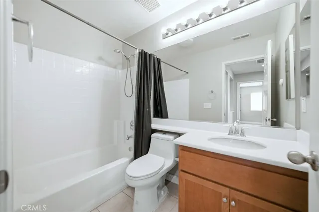 a spacious bathroom with a double vanity sink a large mirror and a bathtub