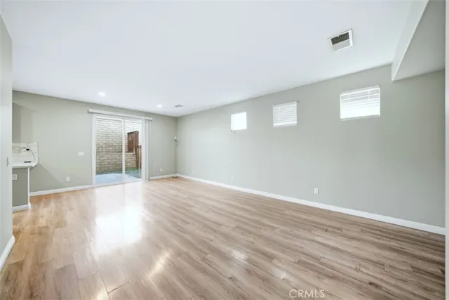 a view of empty room with wooden floor and fireplace