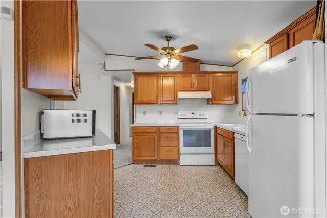 a kitchen with stainless steel appliances granite countertop a refrigerator a stove top oven a sink and dishwasher