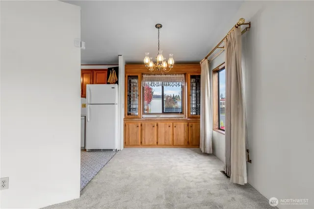 an empty room with chandelier and windows