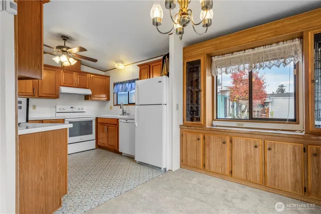 a kitchen with stainless steel appliances granite countertop a stove a sink dishwasher and a refrigerator with wooden floor
