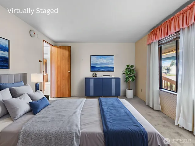 a bedroom with a large bed wooden floor and a window