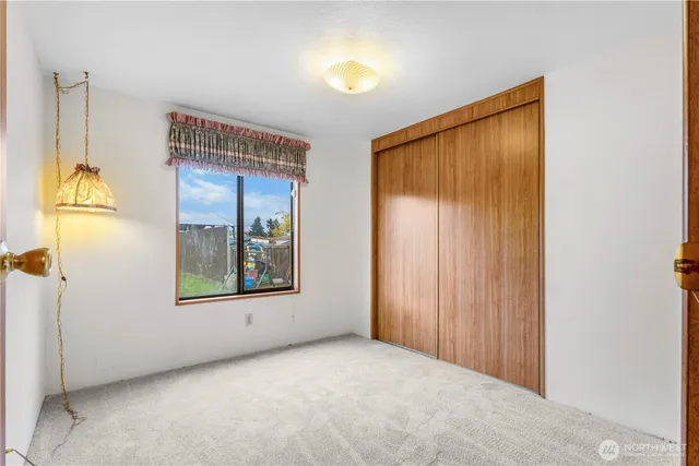 an empty room with windows and mirror