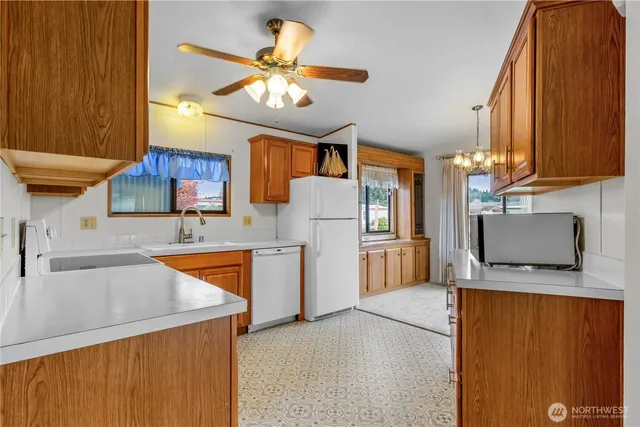 a kitchen with stainless steel appliances granite countertop a sink dishwasher stove top oven and cabinets with wooden floor