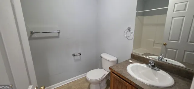 a bathroom with a sink toilet and a mirror