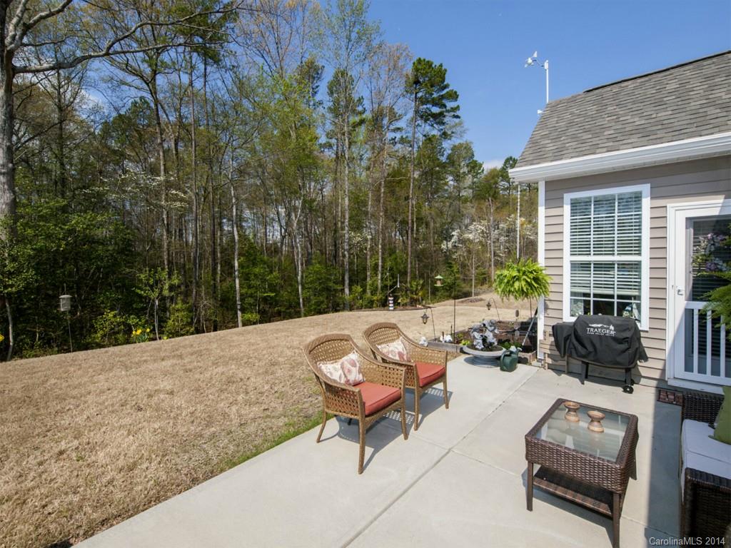 826 Solandra Way Tega Cay, SC 29708 - Photo 19 of 21 a view of a patio with couches and chairs under an umbrella