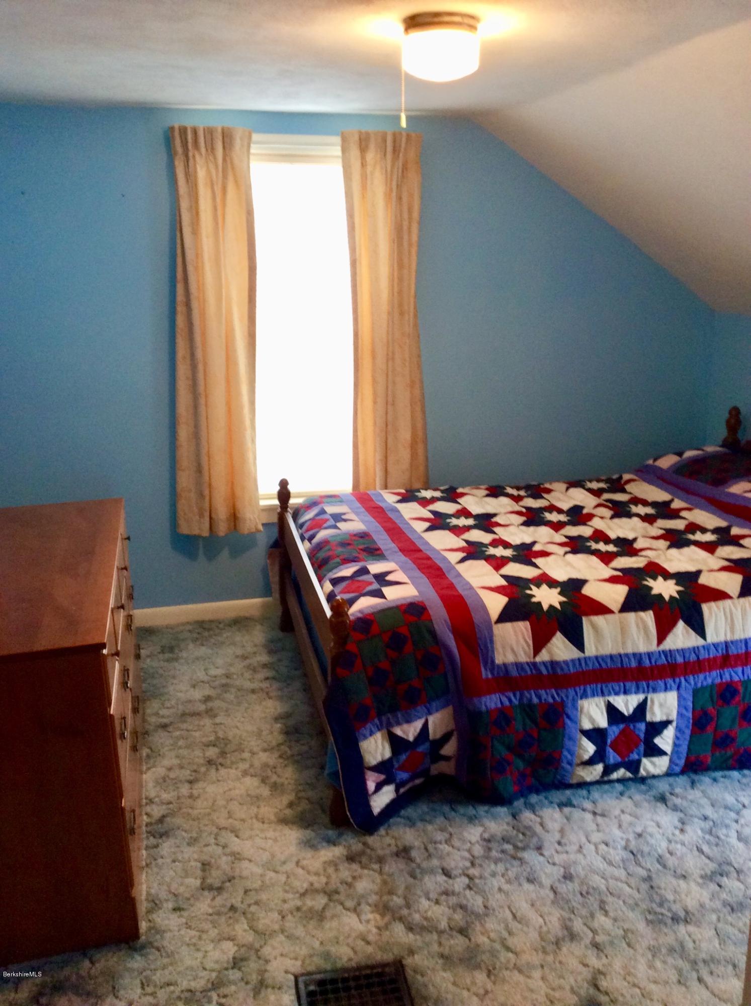 134 Bancroft Road Becket, MA 01223 - Photo 15 of 17 a bedroom with a bed lamp and a large mirror