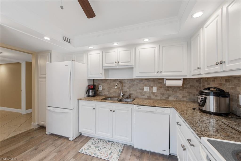 263 Candycane Lane, Unit 5 Naples, FL 34112 - Photo 13 of 49 a kitchen with granite countertop a white refrigerator oven a sink and white cabinets