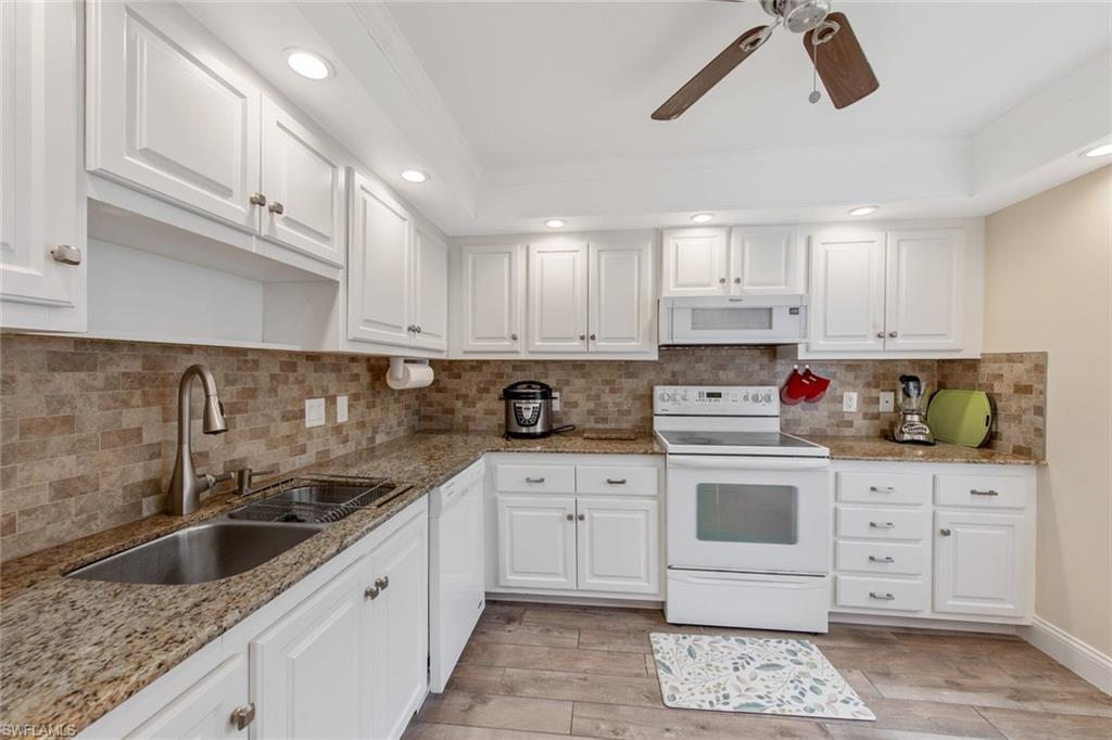 263 Candycane Lane, Unit 5 Naples, FL 34112 - Photo 14 of 49 a kitchen with white cabinets sink and white appliances