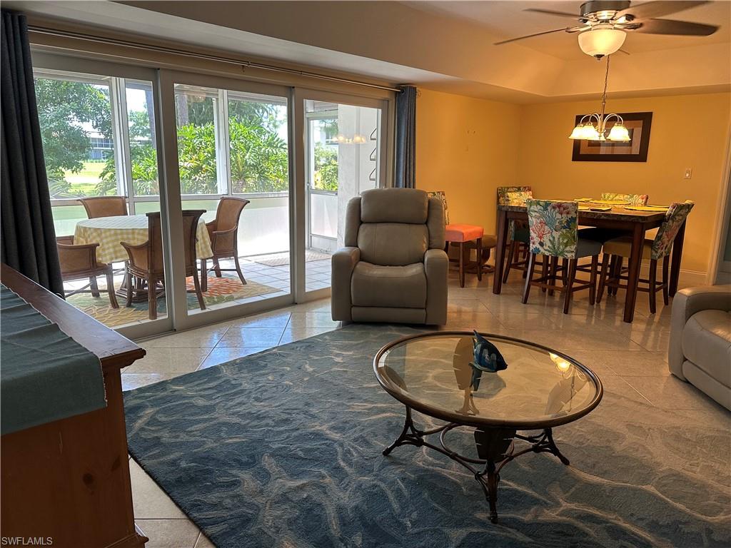 263 Candycane Lane, Unit 5 Naples, FL 34112 - Photo 18 of 49 a living room with furniture a dining table and a floor to ceiling window
