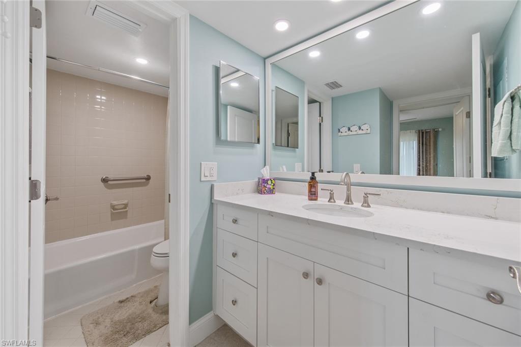 263 Candycane Lane, Unit 5 Naples, FL 34112 - Photo 23 of 49 a bathroom with a tub sink double vanity and mirror