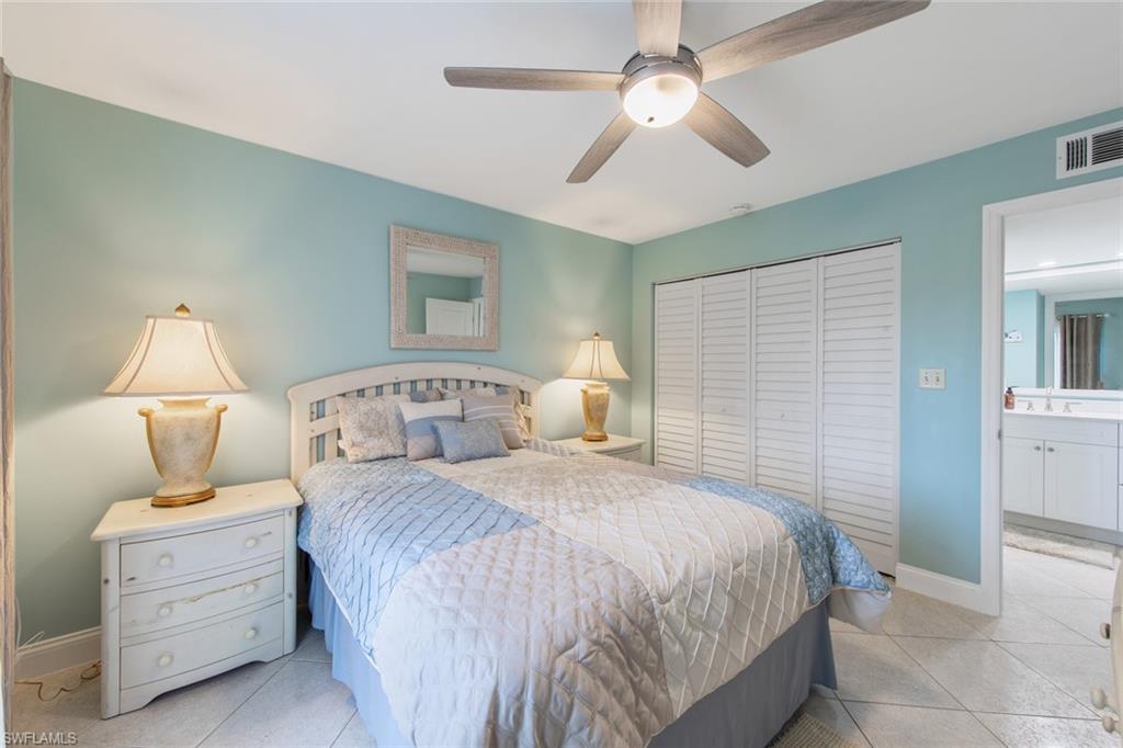 263 Candycane Lane, Unit 5 Naples, FL 34112 - Photo 24 of 49 a bedroom with a bed and a chandelier