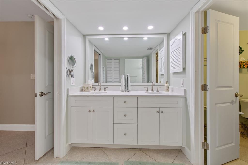 263 Candycane Lane, Unit 5 Naples, FL 34112 - Photo 26 of 49 a bathroom with a double vanity sink a mirror and a bathtub