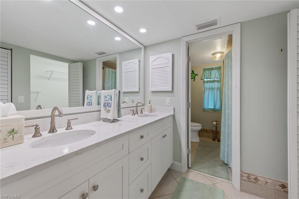 263 Candycane Lane, Unit 5 Naples, FL 34112 - Photo 28 of 49 a spacious bathroom with a double vanity sink a mirror and a bathtub