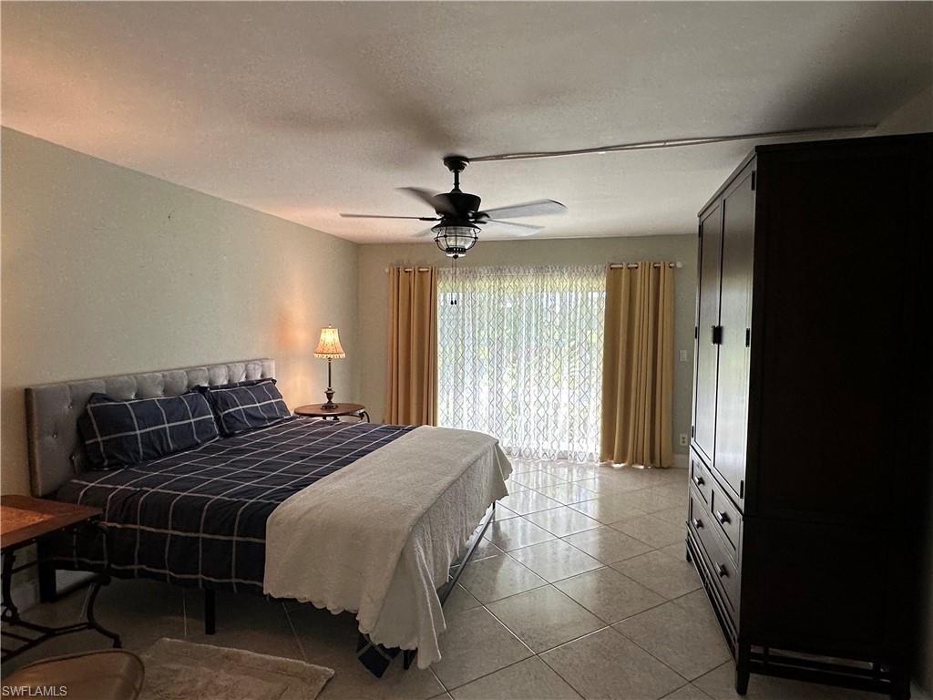 263 Candycane Lane, Unit 5 Naples, FL 34112 - Photo 29 of 49 a bedroom with a bed and a ceiling fan