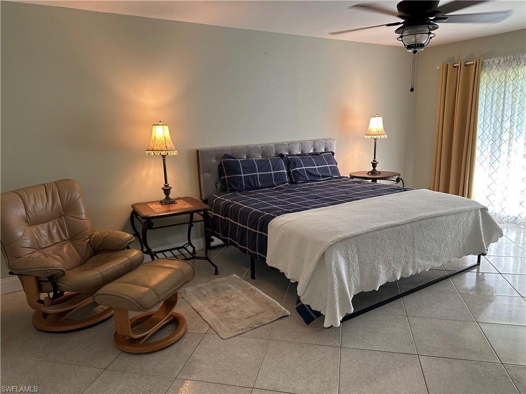 263 Candycane Lane, Unit 5 Naples, FL 34112 - Photo 30 of 49 a spacious bedroom with a bed and a chandelier