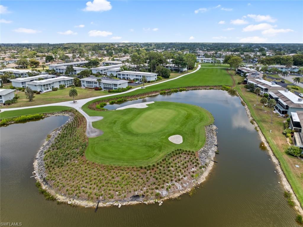 263 Candycane Lane, Unit 5 Naples, FL 34112 - Photo 34 of 49 a view of a swimming pool with a garden