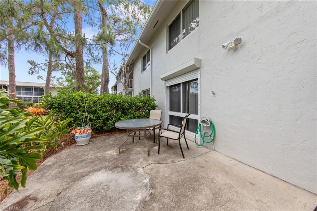 263 Candycane Lane, Unit 5 Naples, FL 34112 - Photo 4 of 49 a view of patio with table and chairs and potted plants
