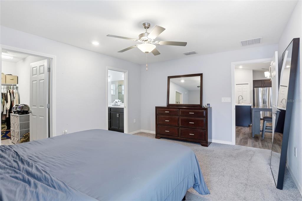 128 Foxtail Loop Davenport, FL 33837 - Photo 12 of 37 a bedroom with a bed and a dresser