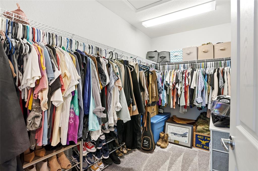 128 Foxtail Loop Davenport, FL 33837 - Photo 13 of 37 a view of walk in closet with clothes