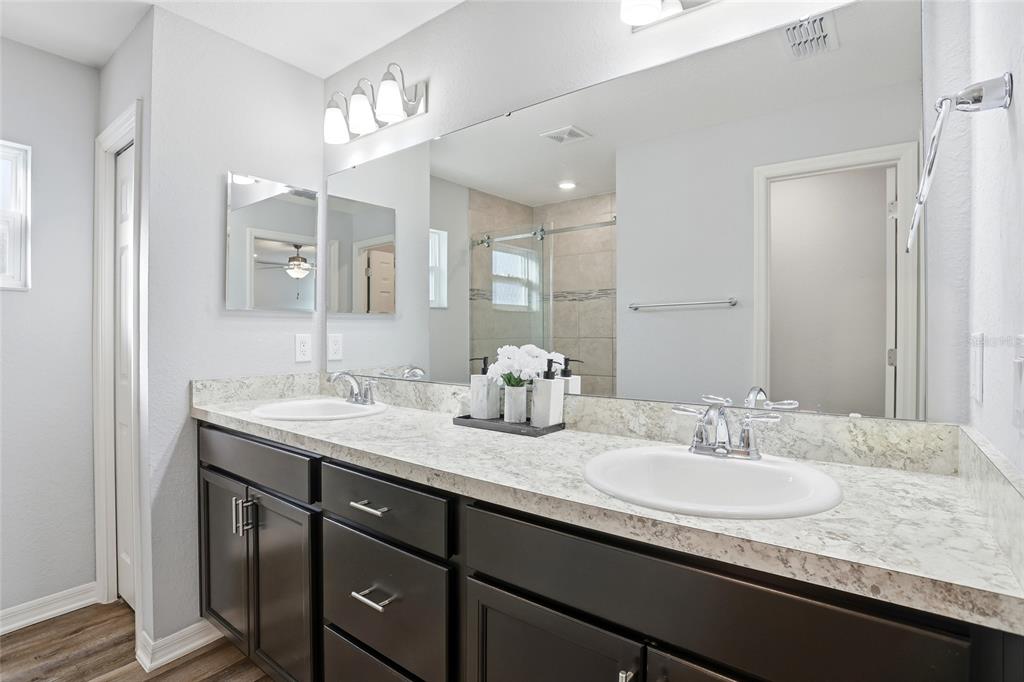 128 Foxtail Loop Davenport, FL 33837 - Photo 14 of 37 a bathroom with a granite countertop sink two mirror and a