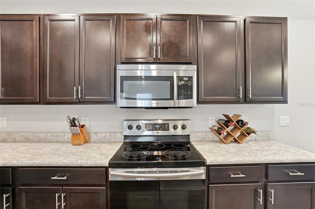128 Foxtail Loop Davenport, FL 33837 - Photo 20 of 37 a kitchen with granite countertop stainless steel appliances and wooden cabinets