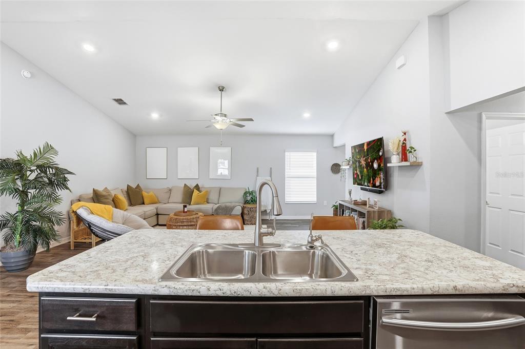128 Foxtail Loop Davenport, FL 33837 - Photo 21 of 37 a kitchen with kitchen island granite countertop a sink and a refrigerator