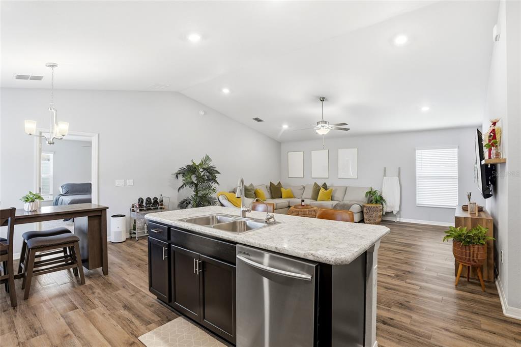 128 Foxtail Loop Davenport, FL 33837 - Photo 22 of 37 a kitchen with a stove a refrigerator and a dining table with wooden floor