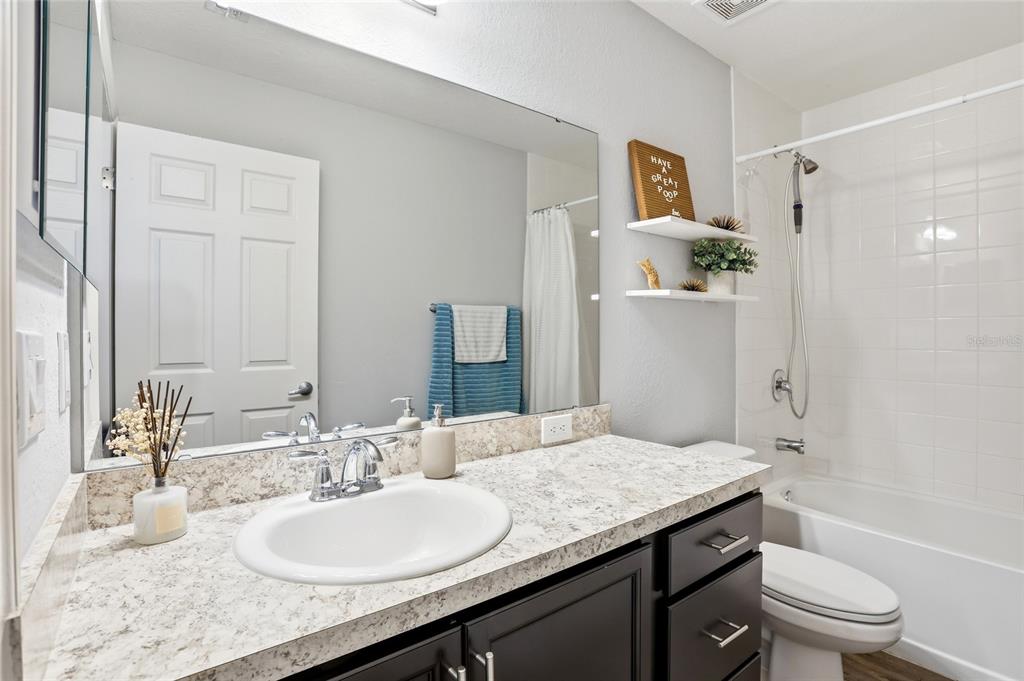 128 Foxtail Loop Davenport, FL 33837 - Photo 24 of 37 a bathroom with a granite countertop sink toilet and shower