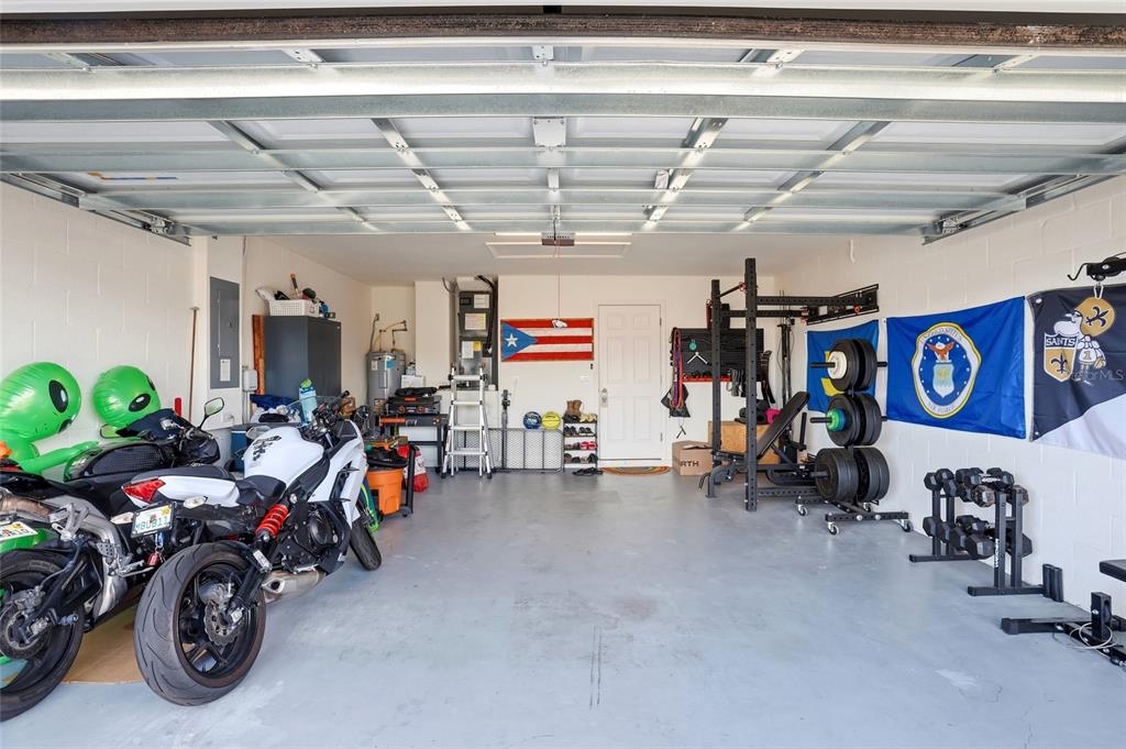 128 Foxtail Loop Davenport, FL 33837 - Photo 5 of 37 a view of a garage with a bike and a car