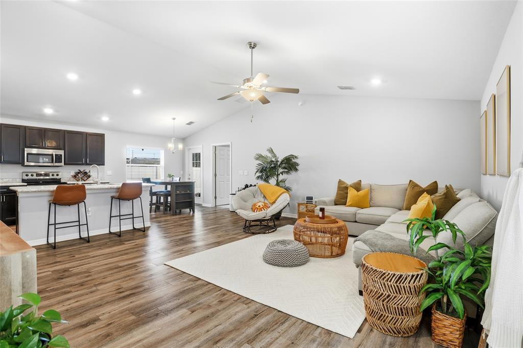 128 Foxtail Loop Davenport, FL 33837 - Photo 8 of 37 a living room with furniture kitchen view and a wooden floor