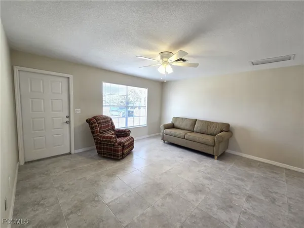 a living room with furniture and a ceiling fan